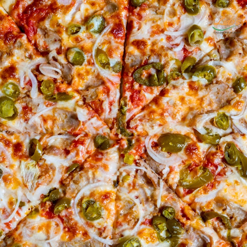 Close-up of a Lido's pizza with melted cheese, tomato sauce, onions, and green peppers.