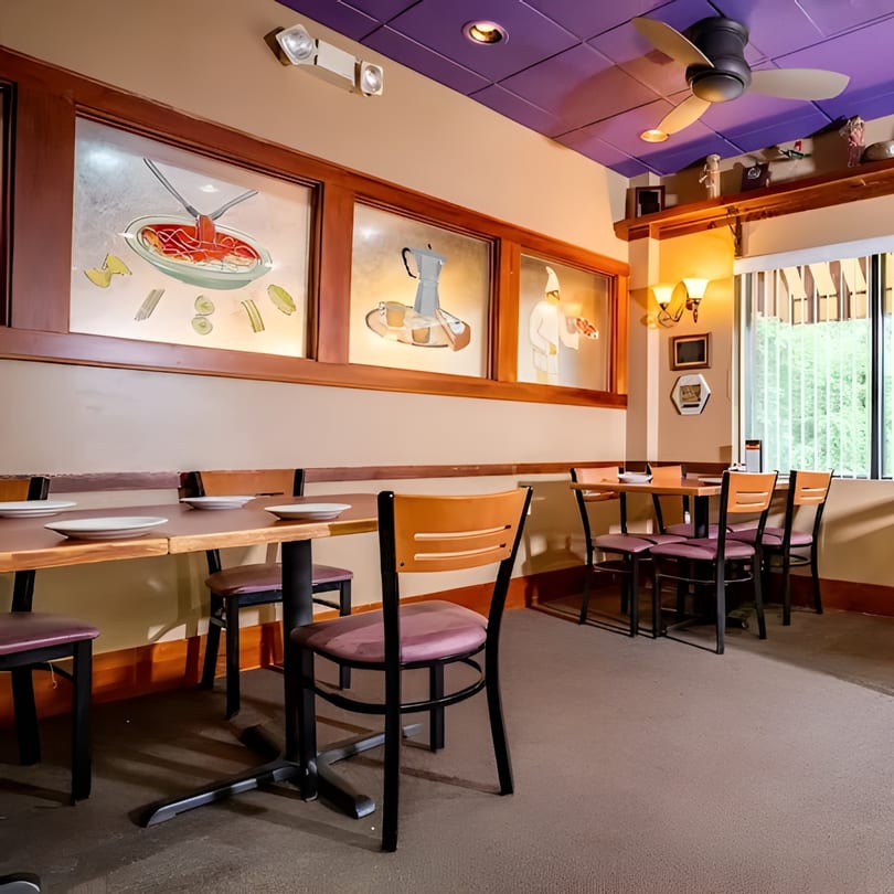 Restaurant dining room with wooden tables, purple chairs, and wall art depicting pasta, coffee, and a chef.